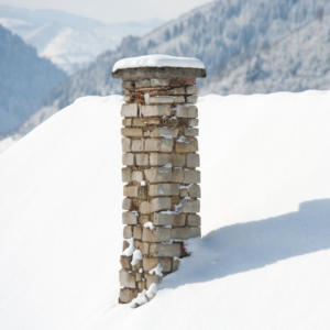gray masonry chimney covered in snow