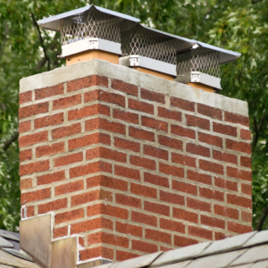 large masonry chimney with three flues and chimney caps