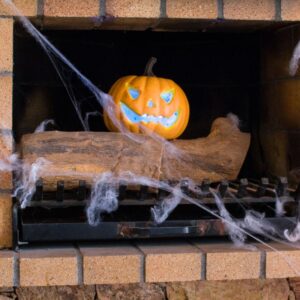 a jack-o-lantern sitting on a log in a masonry firebox surrounded by cobwebs